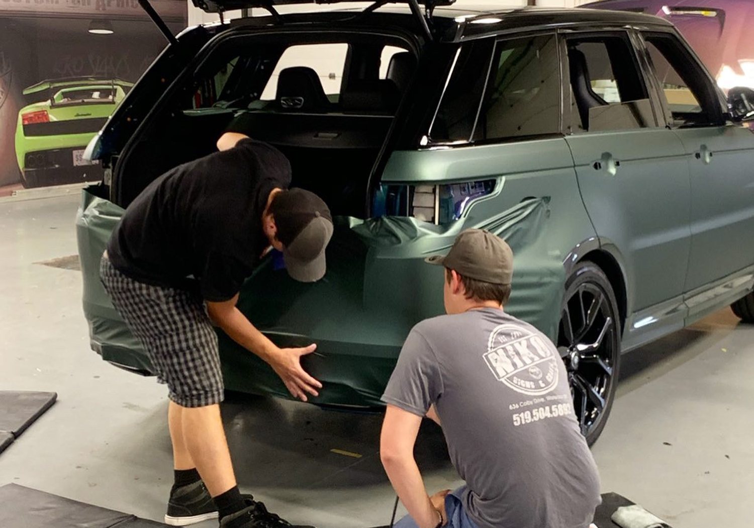 NIKO installers laying colour-change vinyl on a Range Rover — NIKO Signs & GraFX, serving Stratford